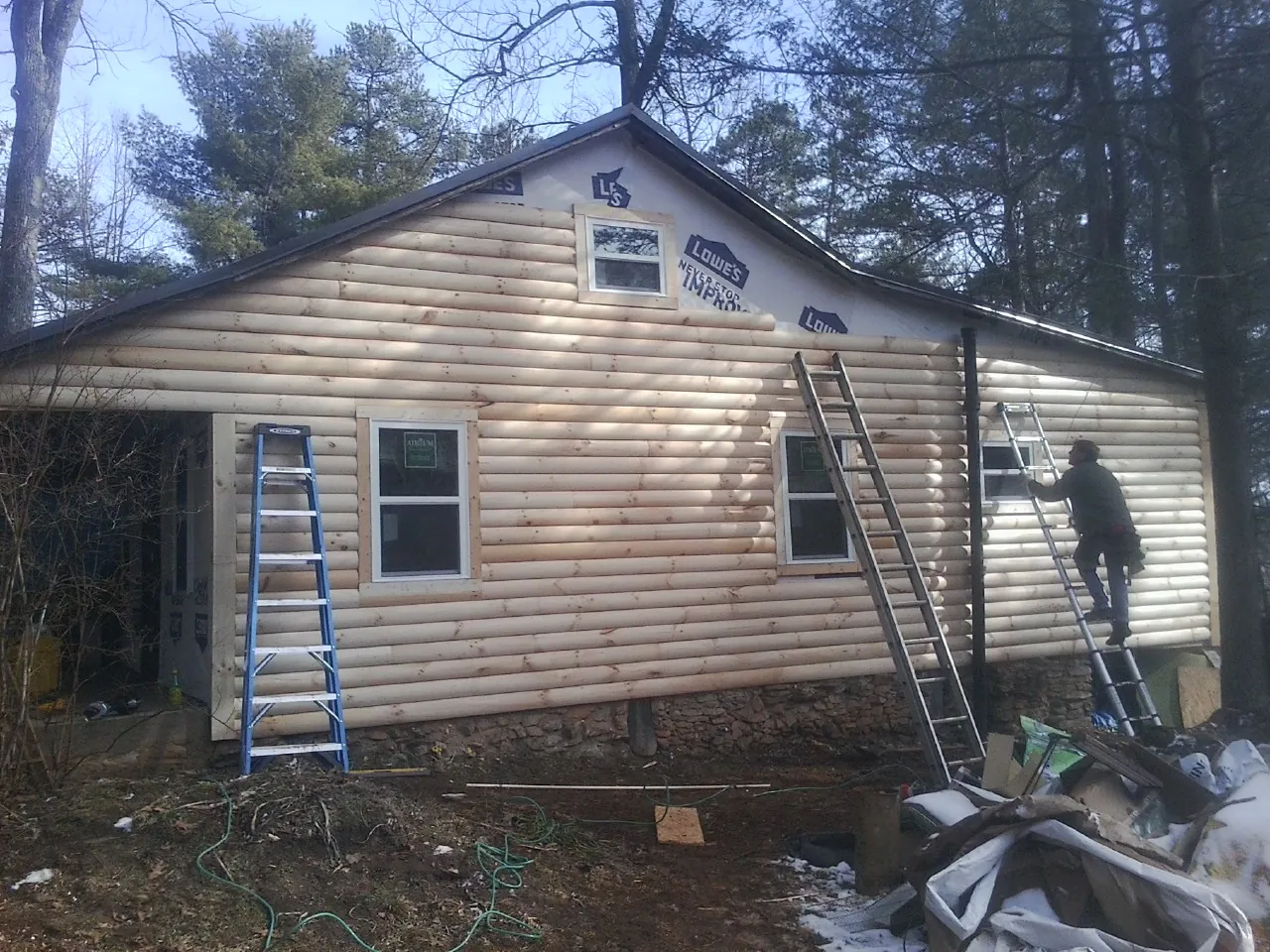 Ladders set against fresh log siding during an exterior remodel in Lakeland