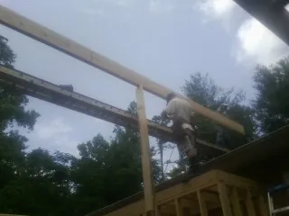 Carpenter setting a ridge beam over a new addition frame — Ice Dam Removal by Roofing Brothers in Lakeland